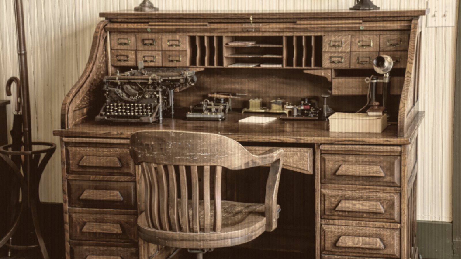 A desk with a chair and a typewriter on it